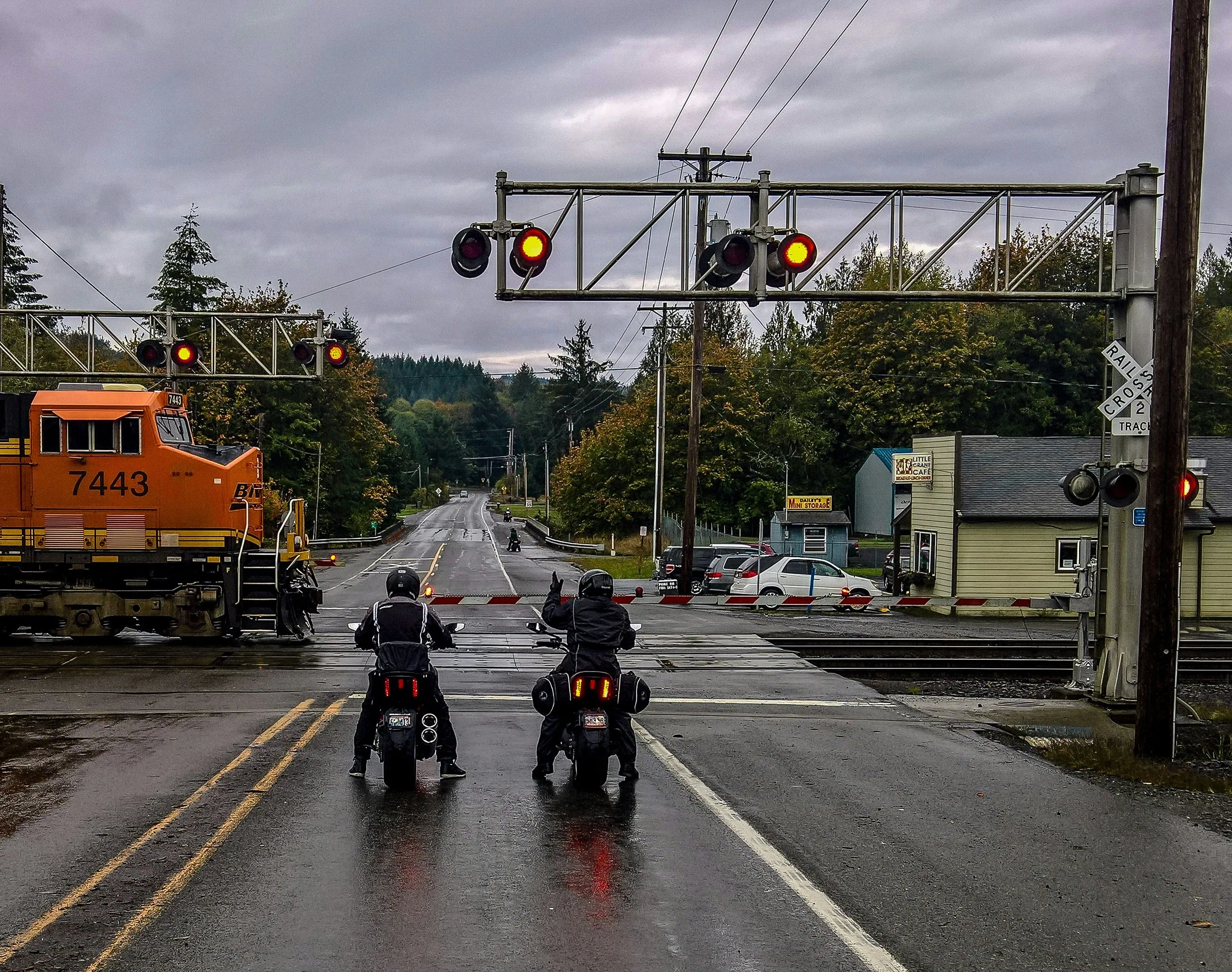 motorcyclists waiting at railroad crossing